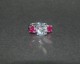 Timeless Trillium Ring in platinum, ring size 4.25.  Center stone is a 9.28mm E/VVS Amora Gem and the side stones are 5.5mm round diamond cut Avarra lab-grown rubies.