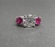 5.5mm Avarra round diamond cut rubies set alongside a 9.28mm E/VVS Amora Gem in our Timeless Trillium Ring.  Platinum and ring size 4.25